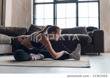 Slim sportswoman in sportswear warming-up muscles 35363408