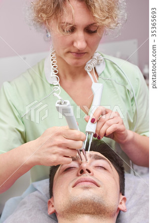 Woman using microcurrent therapy device. Woman using microcurrent therapy device. 35365693