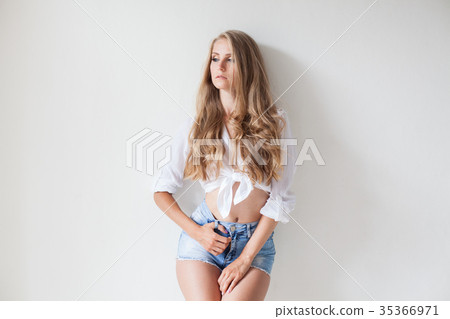 girl in blue shorts blonde posing against a wall girl in blue shorts blonde posing against a wall 35366971