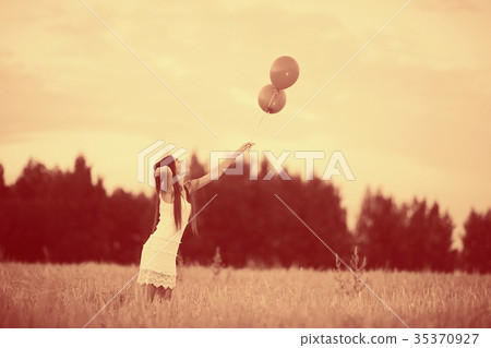 Dream, happiness - young girl in a field with flying balloons Dream, happiness - young girl in a field with flying balloons 35370927