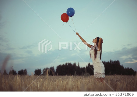 Dream, happiness - young girl in a field with flying balloons Dream, happiness - young girl in a field with flying balloons 35371009