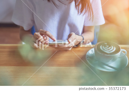 Young girl holding white phone has a blank screen. 35372173