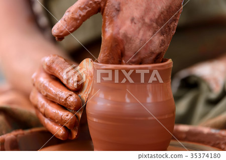 Potter making ceramic pot on the pottery wheel Potter making ceramic pot on the pottery wheel 35374180