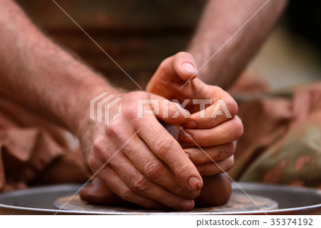 Potter making ceramic pot on the pottery wheel 35374192