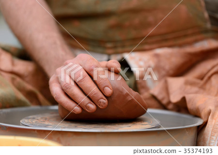 Potter making ceramic pot on the pottery wheel 35374193