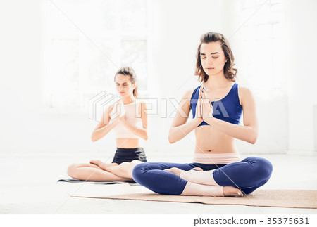 Studio shot of a young women doing yoga exercises 35375631