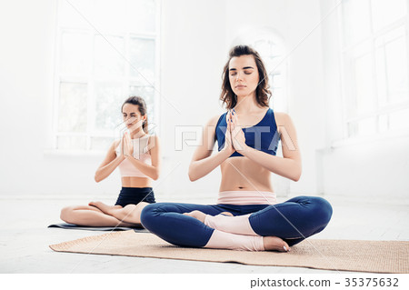 Studio shot of a young women doing yoga exercises Studio shot of a young women doing yoga exercises 35375632