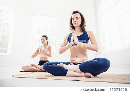 Studio shot of a young women doing yoga exercises Studio shot of a young women doing yoga exercises 35375636
