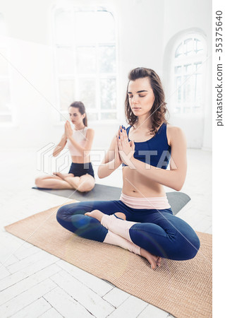 Studio shot of a young women doing yoga exercises 35375640