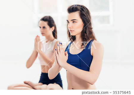 Studio shot of a young women doing yoga exercises Studio shot of a young women doing yoga exercises 35375645