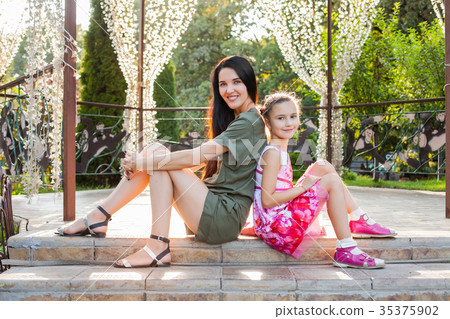 Attractive mom and daughter sitting on stairs in 35375902