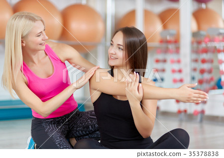 Young woman exercising with her fitness instructor Young woman exercising with her fitness instructor 35378838