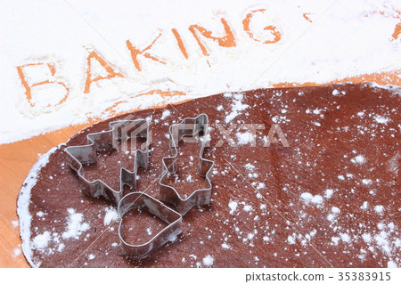 Baking written in flour, cookie cutters and dough Baking written in flour, cookie cutters and dough 35383915