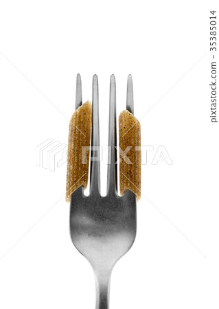 uncooked buckwheat penne rigate in a fork uncooked buckwheat penne rigate in a fork 35385014