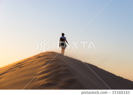 Tourist walking on the sand dunes at Sossusvlei Tourist walking on the sand dunes at Sossusvlei 35388183