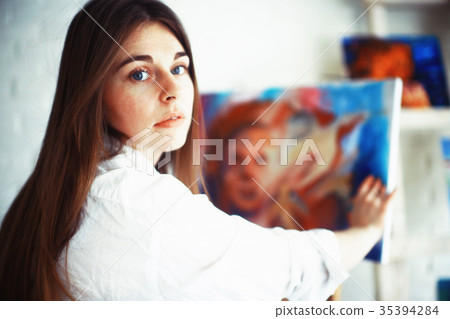 Young artist girl at work in the workshop brush paints canvas inspiration Young artist girl at work in the workshop brush paints canvas inspiration 35394284