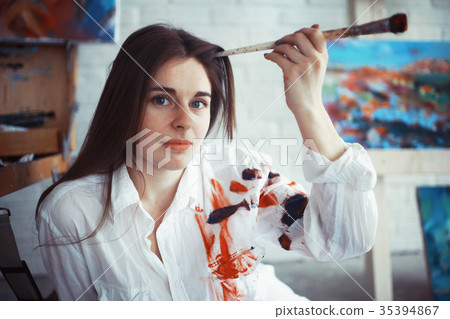 Young artist girl at work in the workshop brush paints canvas inspiration Young artist girl at work in the workshop brush paints canvas inspiration 35394867