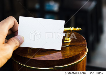 Hand holding white paper on wooden piggy  35400857
