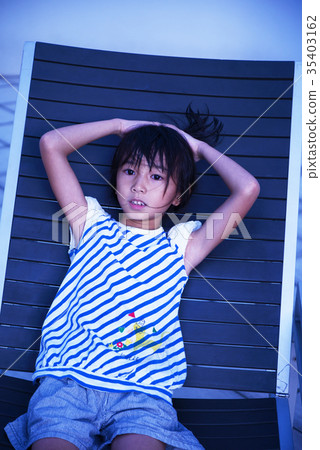 A girl relaxing at the poolside chair 35403162