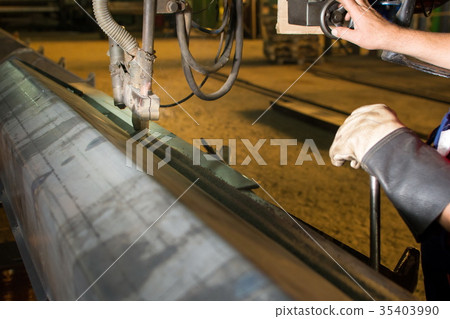 Man operating automated welding machine 35403990