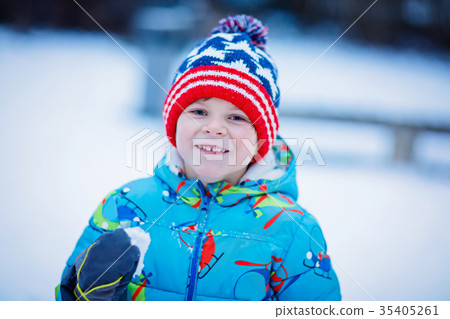 Happy kid boy having fun with snow in winter Happy kid boy having fun with snow in winter 35405261
