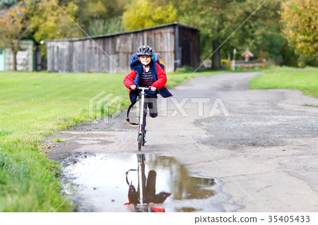Cute preschool kid boy riding on scooter to school Cute preschool kid boy riding on scooter to school 35405433