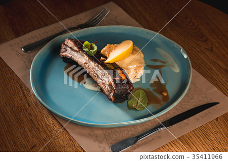 grilled pork ribs on dark plate 35411966
