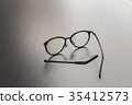 Old black glasses with broken legs. 35412573