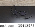 Old black glasses with broken legs. 35412578