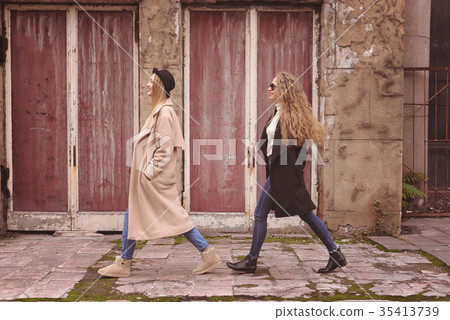 Two stylish girls walking in the city, one by one 35413739