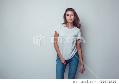 Sexy woman in a white T-shirt on a gray background Sexy woman in a white T-shirt on a gray background 35413835