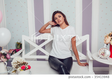 Attractive girl in a white T-shirt is sitting on a Attractive girl in a white T-shirt is sitting on a 35413948