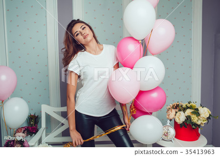 Attractive girl in a white t-shirt holds balloons Attractive girl in a white t-shirt holds balloons 35413963