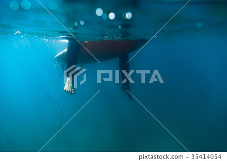 Surfer woman is sitting on surfboard in ocean. 35414054
