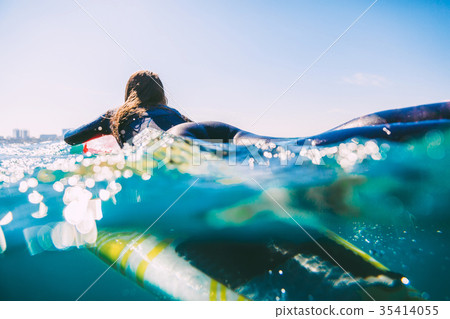 Surfer woman in wetsuit on the surfboard. 35414055