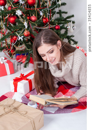 girl reading a book near the Christmas tree 35414855