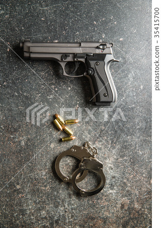 Pistol bullets, handgun and handcuffs. 35415700