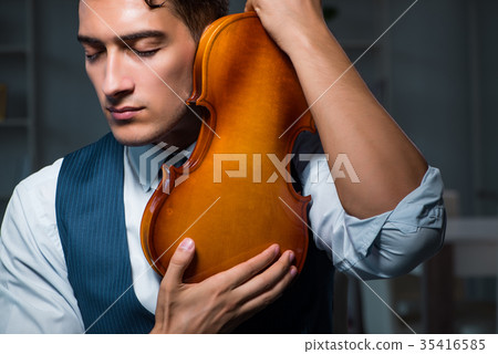 Young musician man practicing playing violin at 35416585