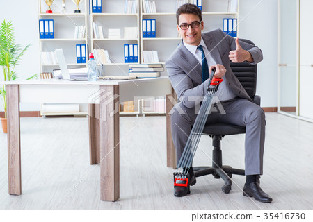Young businessman exercising with elastic expander 35416730