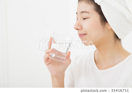 A woman drinking a glass of water 35416731