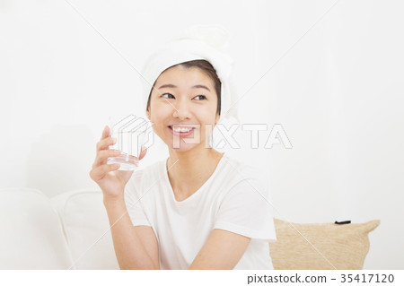 A woman drinking a glass of water A woman drinking a glass of water 35417120