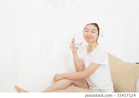 A woman drinking a glass of water A woman drinking a glass of water 35417124