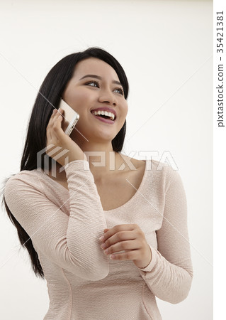 Asian woman talking on mobile phone Asian woman talking on mobile phone 35421381
