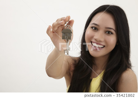 woman holding house shaped key chain woman holding house shaped key chain 35421802