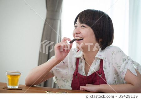 Young housewife eating sweets Young housewife eating sweets 35429119