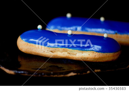 Blue eclairs with a mirrored glaze.A work of Blue eclairs with a mirrored glaze.A work of 35430383