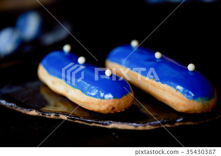 Blue eclairs with a mirrored glaze.A work of Blue eclairs with a mirrored glaze.A work of 35430387