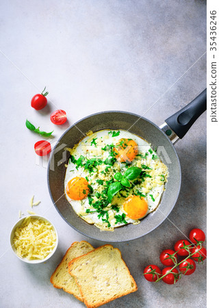 Fried eggs in pan, herbs, spices, cherry tomatoes Fried eggs in pan, herbs, spices, cherry tomatoes 35436246