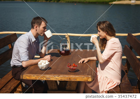 cute couple drinking tea outdoors cute couple drinking tea outdoors 35437472