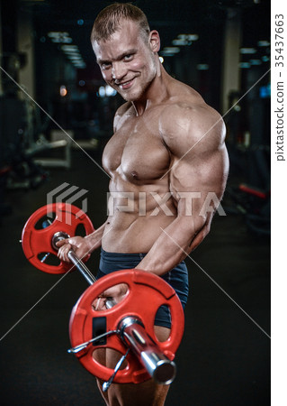 Handsome model young man training arms in gym Handsome model young man training arms in gym 35437663